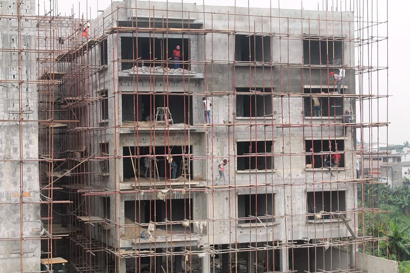 Maçons au travail sur un immeuble en béton en construction